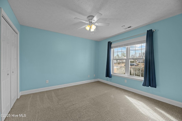 unfurnished bedroom with a closet, carpet flooring, visible vents, and baseboards