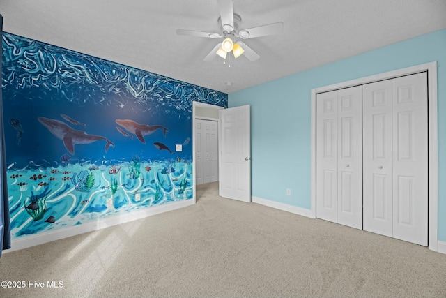 unfurnished bedroom with a ceiling fan, a textured ceiling, baseboards, and carpet flooring