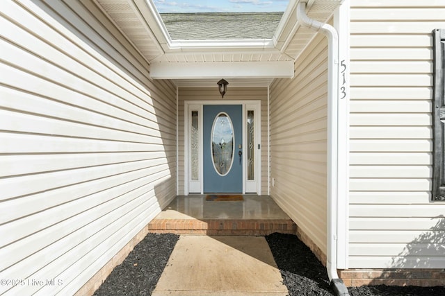 entrance to property featuring a shingled roof