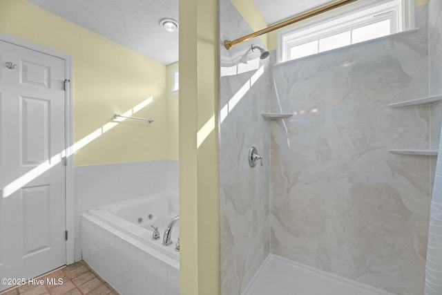 bathroom with a marble finish shower, a tub with jets, a textured ceiling, and tile patterned floors