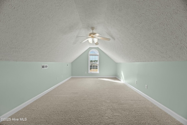 bonus room featuring lofted ceiling, carpet flooring, visible vents, and baseboards