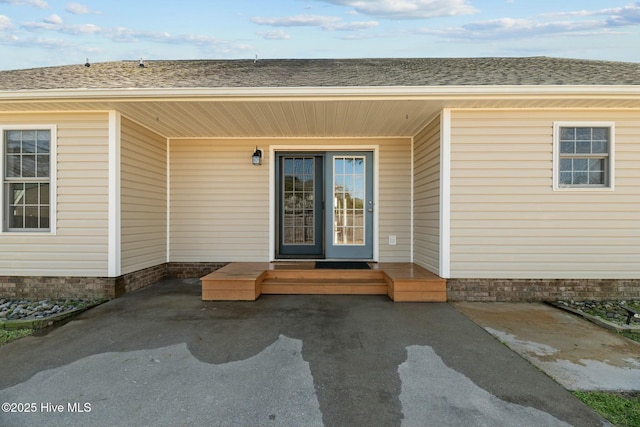 property entrance with a shingled roof