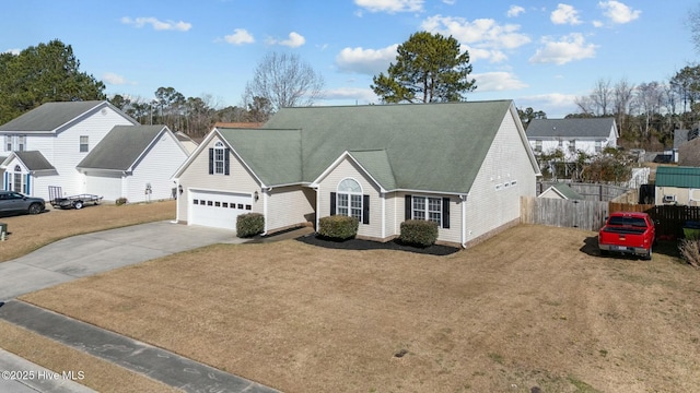 view of front of house featuring a residential view, driveway, a front lawn, and fence