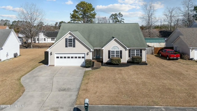 view of front of home with driveway, roof with shingles, fence, and a front yard