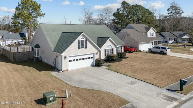 traditional-style house with roof with shingles, fence, cooling unit, driveway, and a front lawn