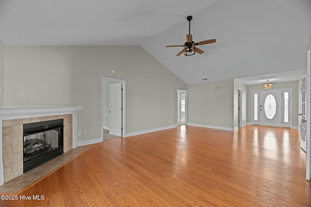 unfurnished living room featuring a fireplace, a ceiling fan, wood finished floors, high vaulted ceiling, and baseboards