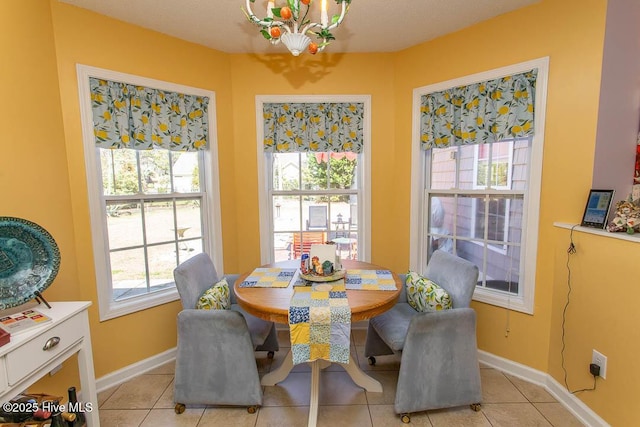 dining room featuring an inviting chandelier, baseboards, and light tile patterned flooring