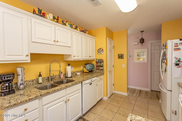 kitchen with white appliances, a sink, visible vents, and white cabinetry