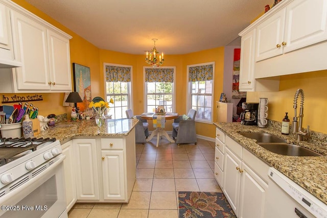 kitchen with light tile patterned flooring, a sink, white cabinets, a chandelier, and white appliances