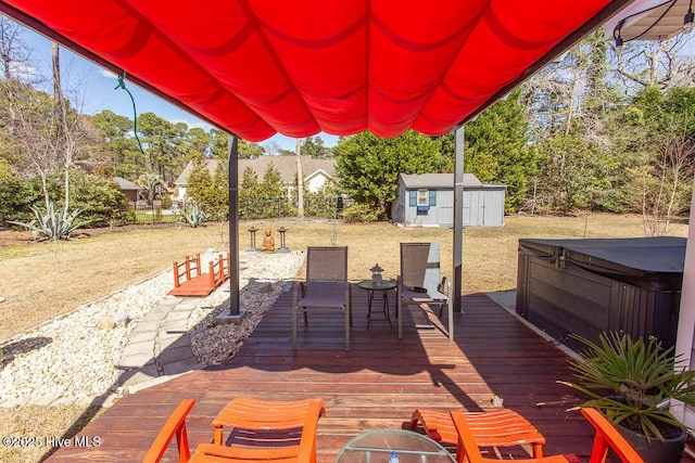 exterior space with a storage shed, a hot tub, a deck, and an outdoor structure