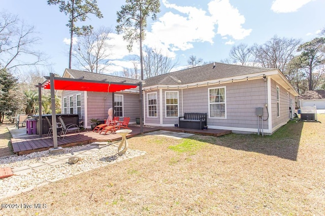 back of property with a lawn, a wooden deck, and a hot tub