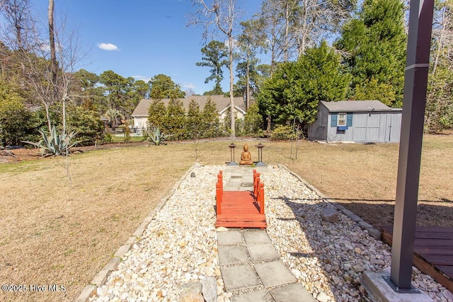 view of yard with a storage shed, an outdoor structure, and fence