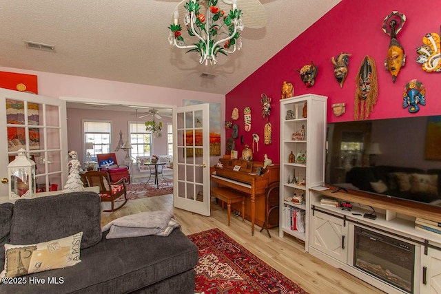 living area with ceiling fan, a textured ceiling, visible vents, french doors, and light wood-type flooring