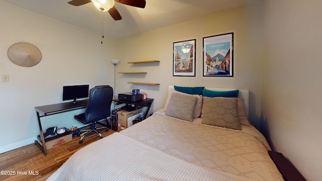 bedroom featuring ceiling fan, baseboards, and wood finished floors