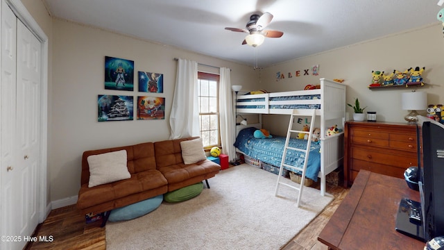 bedroom with a closet, wood finished floors, and a ceiling fan