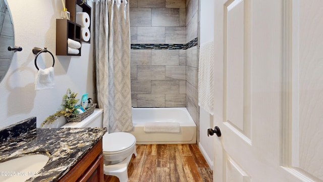 full bath featuring vanity, shower / bath combo with shower curtain, wood finished floors, and toilet