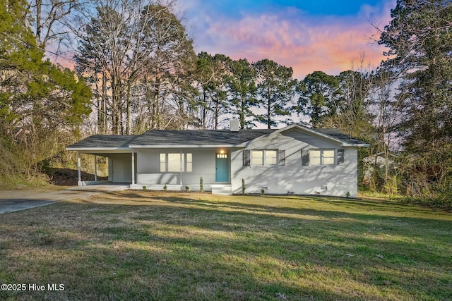 ranch-style house with a carport, a front lawn, and concrete driveway