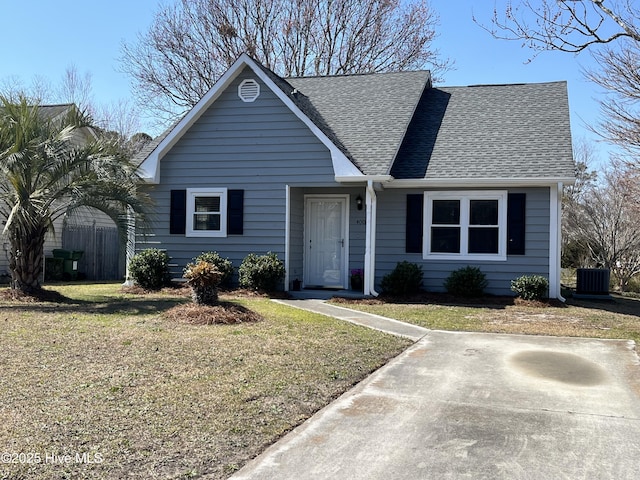 view of front of house with a front yard, roof with shingles, and central AC