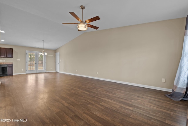 unfurnished living room with baseboards, dark wood-type flooring, ceiling fan with notable chandelier, and vaulted ceiling