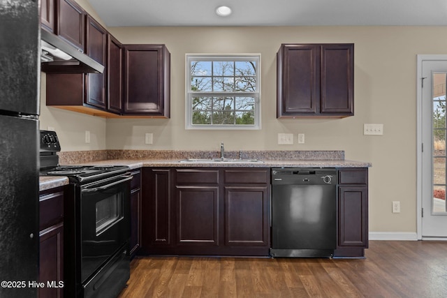 kitchen featuring black appliances, dark wood-style flooring, a wealth of natural light, and a sink