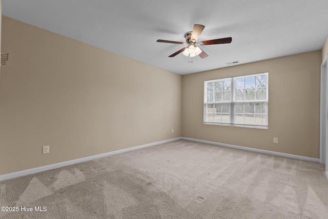 empty room with visible vents, carpet, baseboards, and ceiling fan