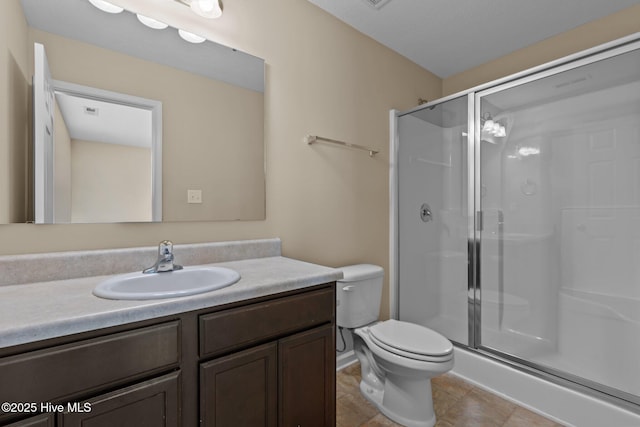 full bath with vanity, visible vents, tile patterned flooring, a shower stall, and toilet