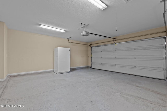 garage featuring a garage door opener, baseboards, and freestanding refrigerator