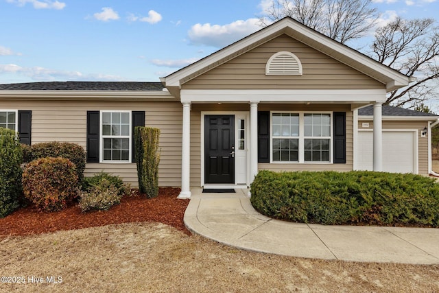 view of front facade featuring a garage and a shingled roof