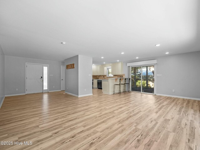 kitchen featuring stainless steel appliances, light countertops, a sink, and light wood finished floors