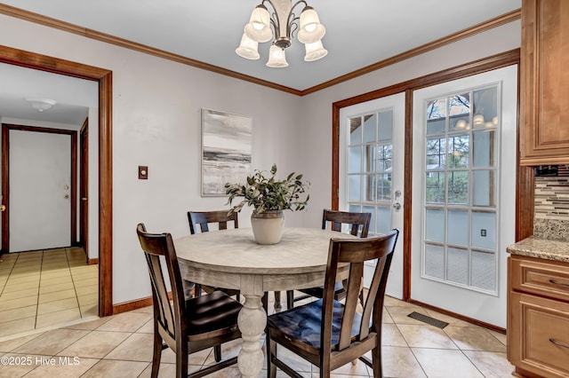 dining room with light tile patterned floors, baseboards, visible vents, crown molding, and a notable chandelier