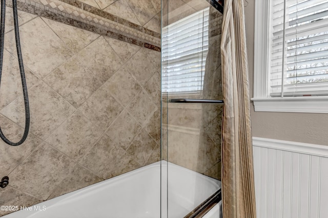 bathroom with a wainscoted wall and shower / bathing tub combination