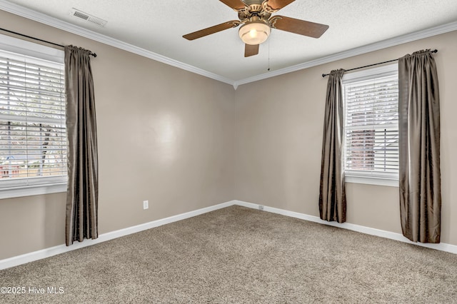 carpeted empty room featuring a ceiling fan, crown molding, visible vents, and a textured ceiling