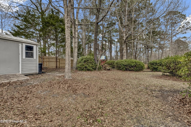 view of yard featuring an outbuilding and fence