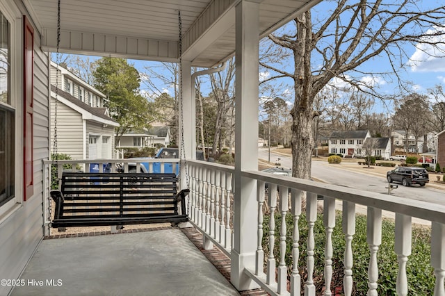 balcony featuring covered porch and a residential view