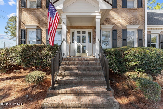 doorway to property with brick siding