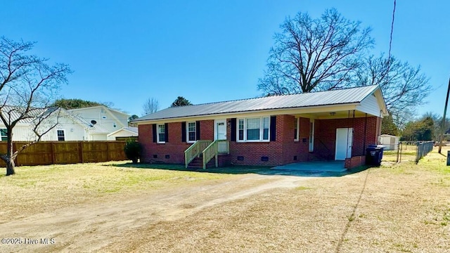 ranch-style home featuring dirt driveway, brick siding, crawl space, and fence