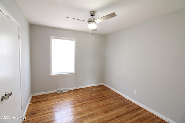 spare room with light wood-style flooring, visible vents, ceiling fan, and baseboards