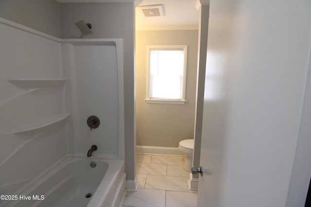 bathroom with toilet, marble finish floor, baseboards, and bathing tub / shower combination