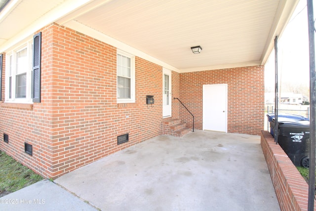 view of patio featuring entry steps, driveway, and an attached carport