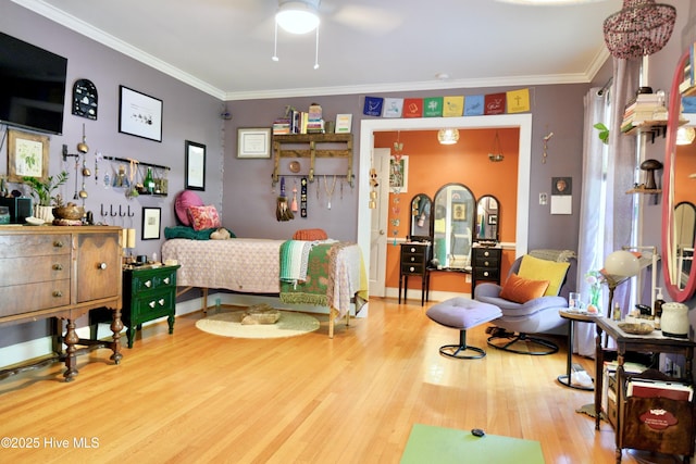 bedroom with ornamental molding and wood finished floors