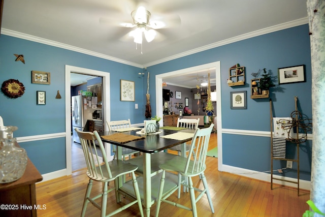 dining area featuring ceiling fan, ornamental molding, wood finished floors, and baseboards