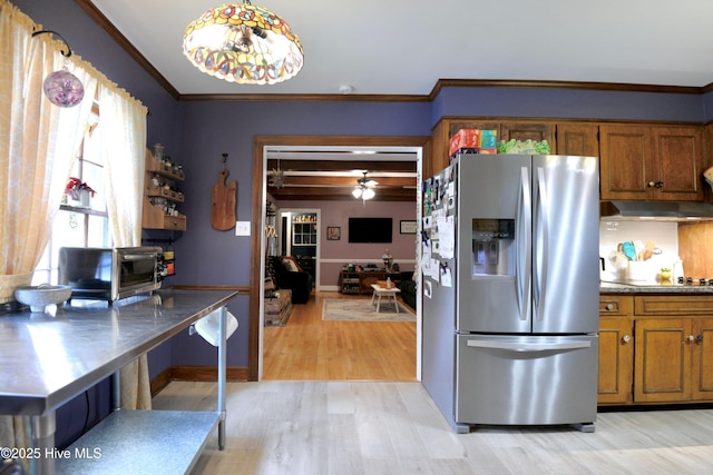 kitchen featuring stainless steel refrigerator with ice dispenser, brown cabinetry, light wood-style floors, ornamental molding, and under cabinet range hood