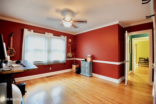 office area featuring baseboards, light wood finished floors, visible vents, and crown molding