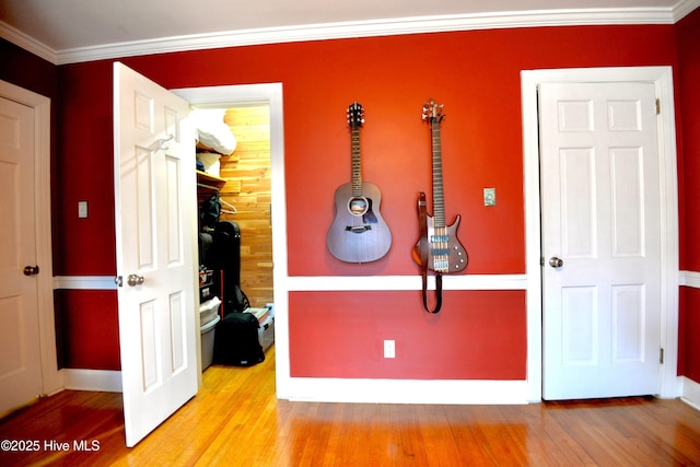 interior space featuring light wood-style floors, baseboards, and ornamental molding