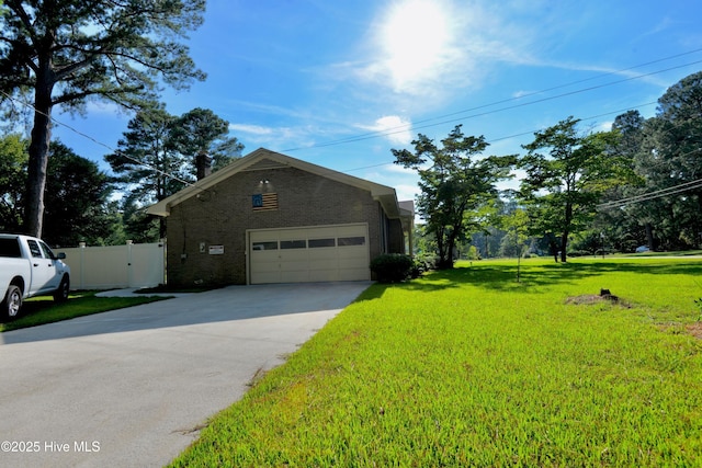 exterior space featuring concrete driveway, a lawn, an attached garage, fence, and brick siding