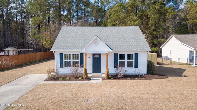 bungalow-style house featuring a front yard, roof with shingles, and fence