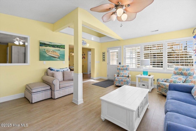 living room with light wood-type flooring, baseboards, a ceiling fan, and lofted ceiling