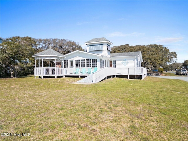 back of house featuring a deck, a lawn, and a gazebo