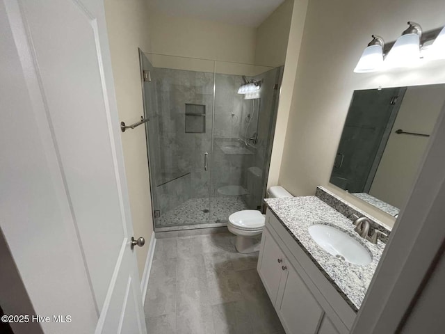 bathroom featuring a stall shower, vanity, and toilet