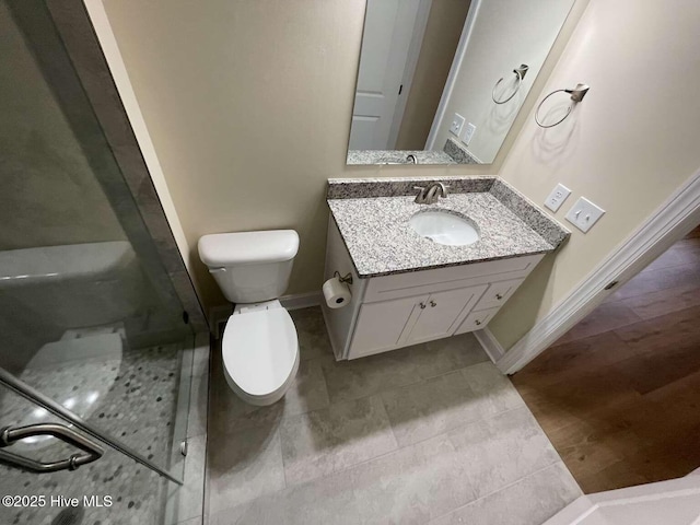 full bath featuring baseboards, a shower stall, toilet, and vanity